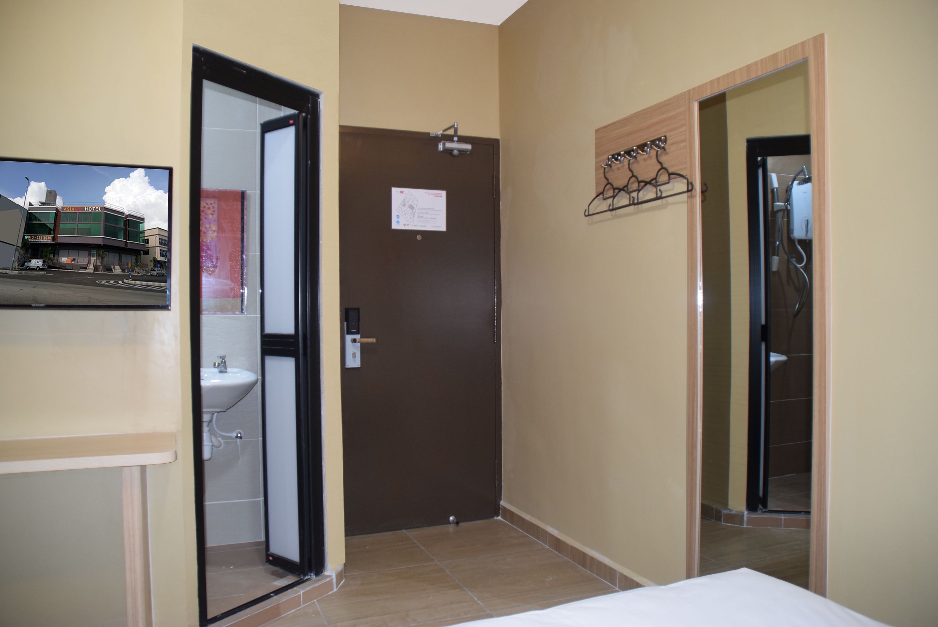 Ein Hotelzimmer mit Bett, Bad mit Waschbecken und Dusche.