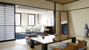 A traditional Japanese tatami room with a low table, cushions, and sliding doors. - Luke Plaza Hotel (Nagasaki)