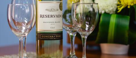 A bottle of Reserva Sauvignon Blanc 2018, two empty wine glasses, and a bouquet of flowers on a table.