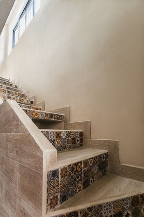 A staircase with patterned tiles and wooden steps. - Suite Studio Serviced Apartments (Mérida)