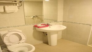 Un baño con inodoro, lavamanos y espejo.
