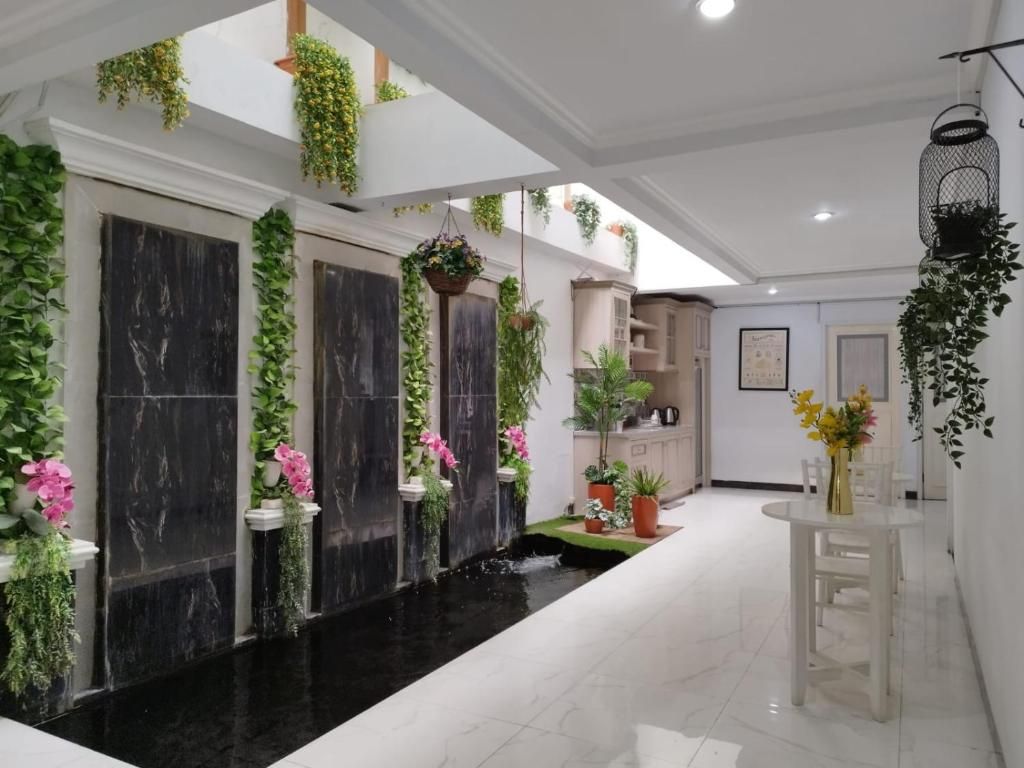 A modern interior with a black marble water feature, white walls, and greenery.