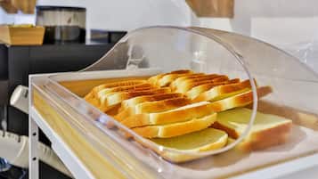 A buffet with a clear plastic cover displaying sliced bread.