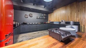 A modern kitchen with grey cabinets, a red fridge, and a wooden accent wall. - Anyang Premier Hotel XYM (Anyang)