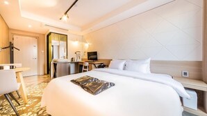 A modern hotel room with a large bed, a desk, a chair, and a mirror. - Anyang Premier Hotel XYM (Anyang)