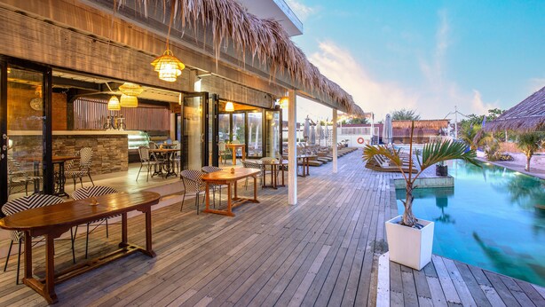 A wooden deck with outdoor seating, a pool, and a thatched roof structure. - FRii Resort Gili Trawangan (Gili Trawangan)