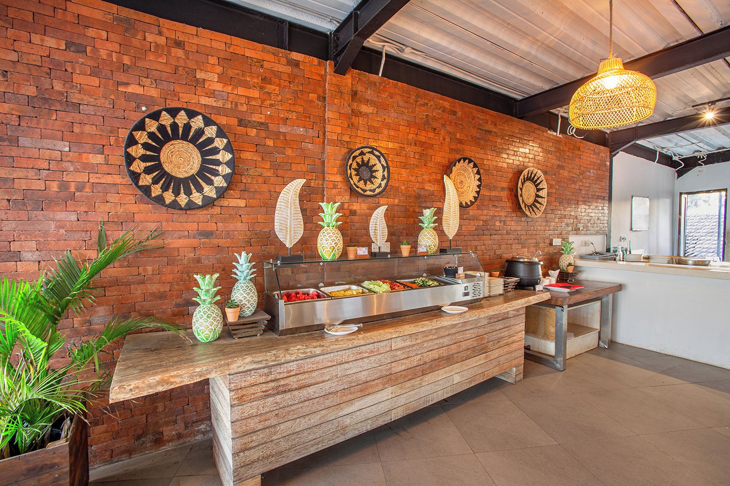Zona de bufé con pared de ladrillo, platos decorativos y mostrador de madera.
