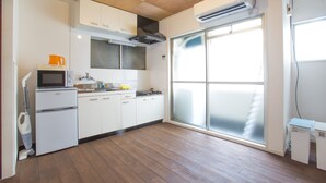 Een moderne keuken met witte kasten, een magnetron en een koffiezetapparaat.