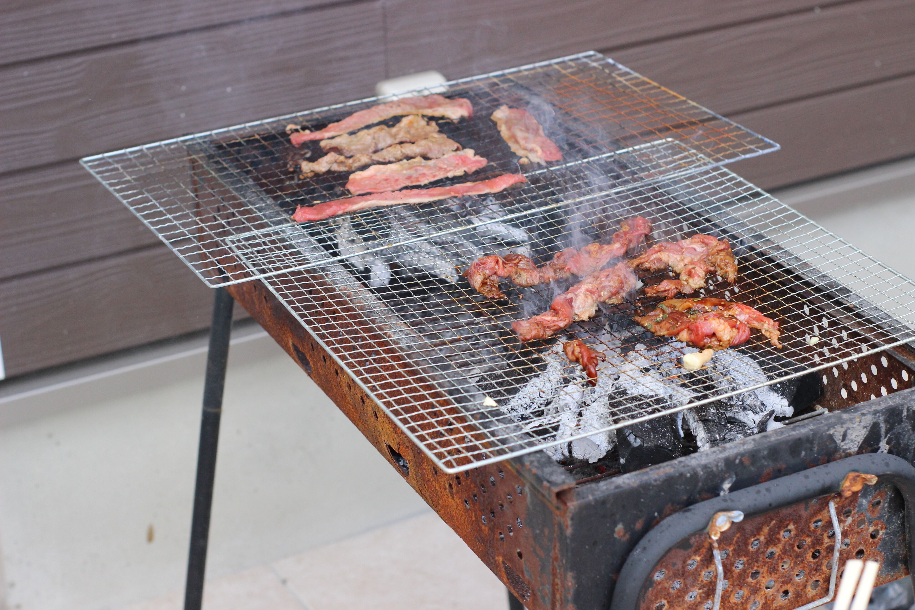 Una parrilla con carne cocinándose sobre una rejilla de metal.