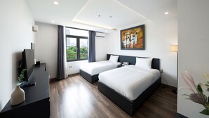 Habitación de hotel moderna con dos camas, un televisor de pantalla plana, un escritorio y un amplio ventanal con vistas a la ciudad.