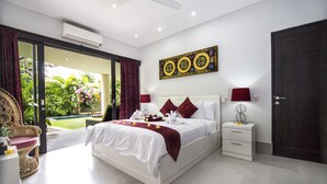Une chambre spacieuse avec un grand lit, une table de chevet et une vue sur un jardin, accessible par une porte-fenêtre coulissante.