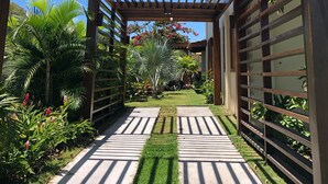 Una estructura de pérgola de madera con un sendero despejado que lleva a un área cubierta.