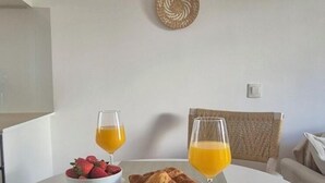 A dining table with a bowl of strawberries, a croissant, and two glasses of orange juice. - Entire apartment in Costa Adeje (Costa Adeje)