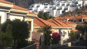 A coastal town with terracotta-tiled buildings, a clear blue sky, and mountains in the background. - Entire apartment in Costa Adeje (Costa Adeje)