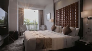 Une chambre d’hôtel avec un grand lit, une télévision, un bureau et une chaise.