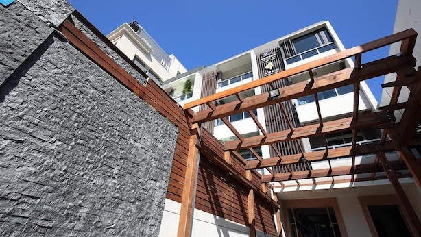 A modern building with a stone facade and wooden balcony railings. - A-Ba Homestay  (Hualien City)