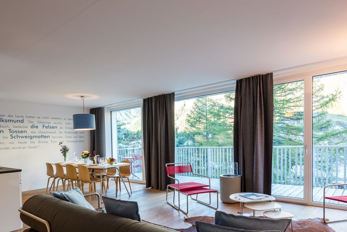 Un salon moderne avec un coin repas, de grandes fenêtres et un balcon.