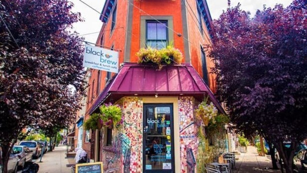 A building with a colorful exterior and a sign for 'black brew' cafe. - Beautiful 1BD Apt with Roofdeck in Passyunk Square (Philadelphia)