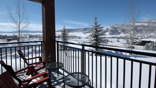 A balcony with a view of a snowy landscape and mountains.