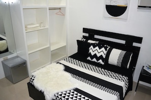 A bedroom with a bed, a wardrobe, and a small fridge. - Sergi's Resort and Hotel (Palompon)