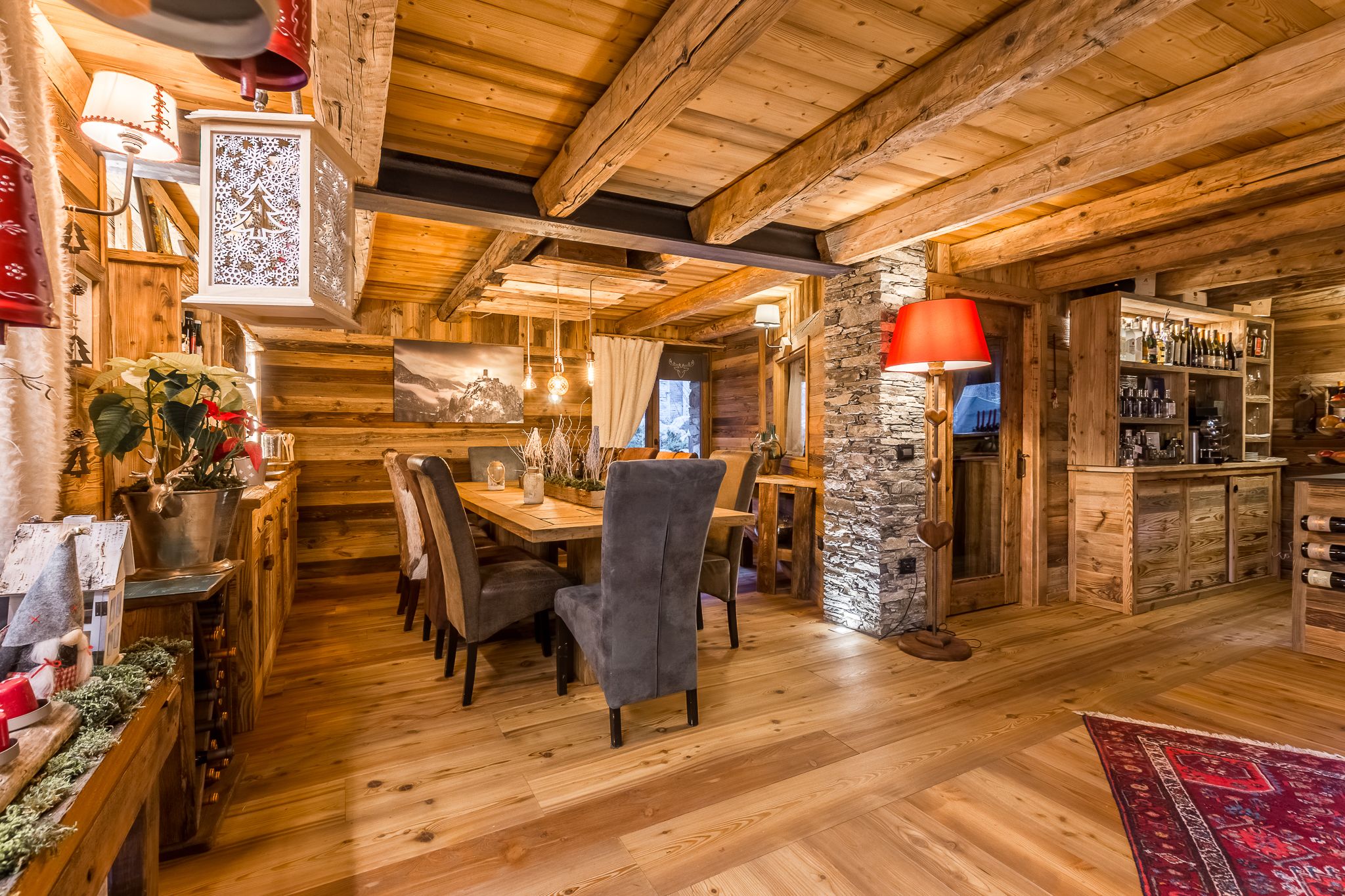 Un intérieur rustique en bois, avec un coin repas, des éléments décoratifs en pierre et un bar.