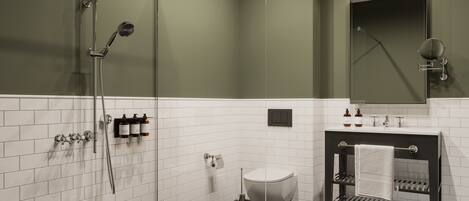 A modern bathroom with a glass-enclosed shower, a white toilet, and a vanity with a towel rack.