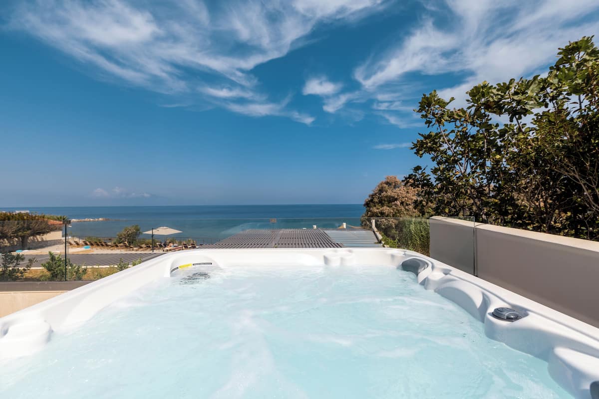 Un jacuzzi con vista al océano y un cielo despejado.