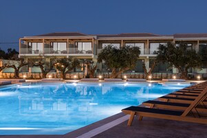 Una piscina al aire libre, sombrillas, sillones reclinables de piscina