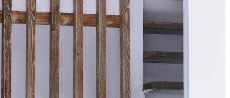Una escalera con barandillas de madera y paredes blancas.