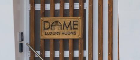 Una puerta con un letrero que dice "DOME LUXURY ROOMS".