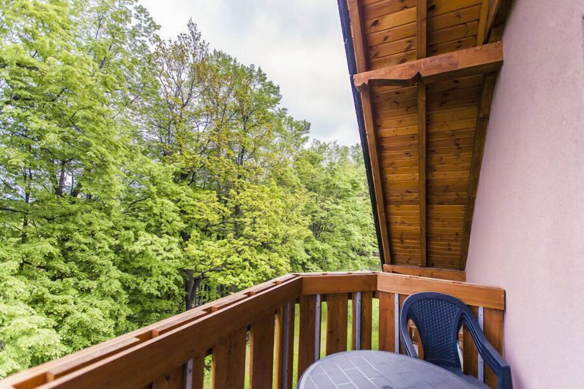 Una terraza de madera con vistas a un bosque frondoso.