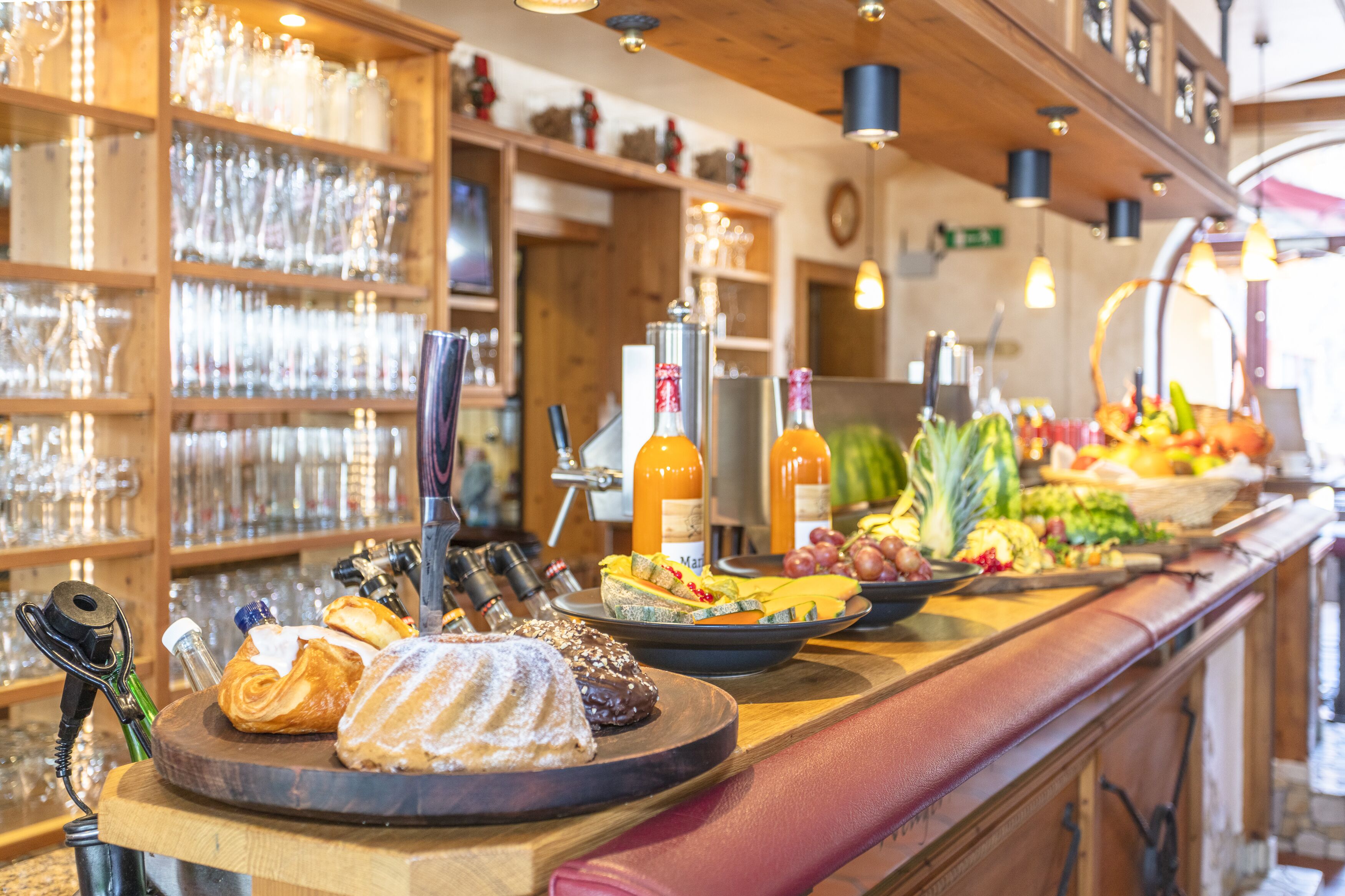 A buffet with various food items and a selection of wine bottles.