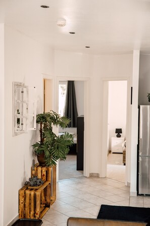 A modern kitchen with a refrigerator, wooden cabinets, and a potted plant. - Down Town Motel (Berlin)