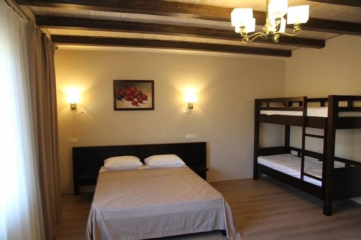 A bedroom with a single bed, a bunk bed, and two wall-mounted lights.