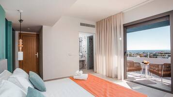 Habitación de hotel con cama, baño y balcón con vistas.