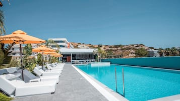 Een buitenzwembad, parasols voor strand/zwembad