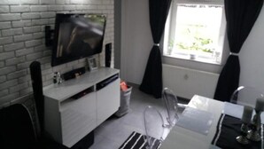 A modern kitchen with a built-in oven, a white countertop, and a window with black curtains. - EverySky Karpacz 3 Maja 66 (Karpacz)