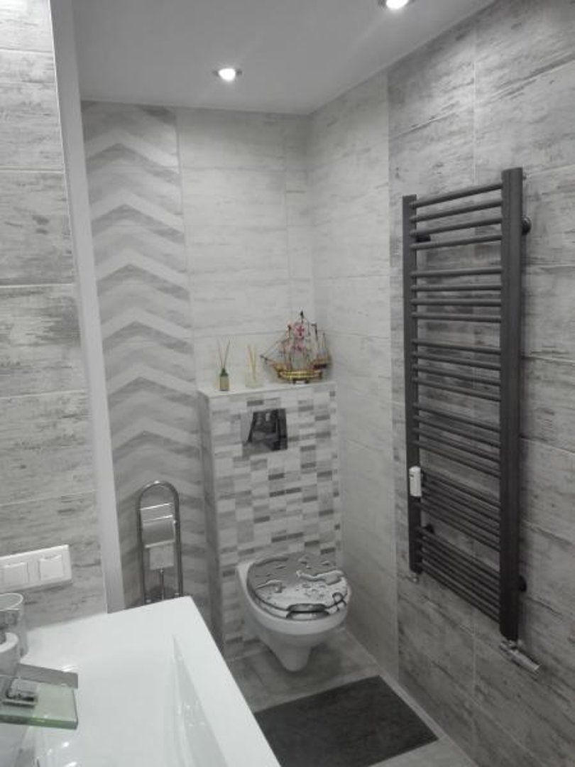 A bathroom with a modern design, featuring a shower, toilet, and a towel rack.