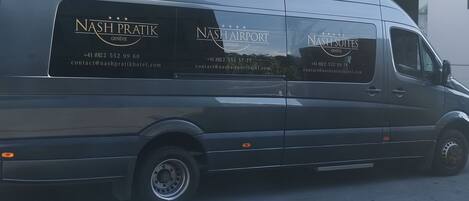 Una camioneta negra con la marca 'Nash Pratik Geneva' y 'Nash Airport Geneva', información de contacto y una URL de sitio web.