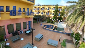 A courtyard with outdoor seating, a pool, and a multi-story building with balconies. - C'est La Vie (Magong)