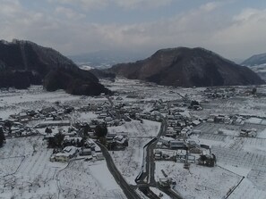 Un village enneigé, avec des maisons traditionnelles et une route sinueuse.
