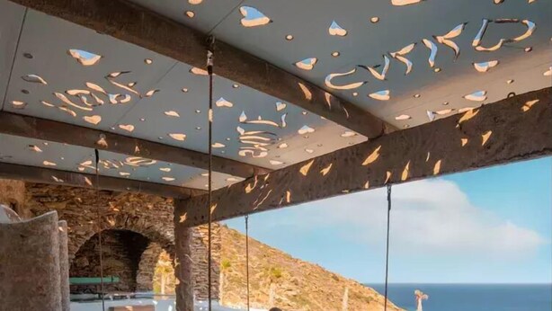 A private outdoor hot tub with a view of the sea, a stone archway, and a wooden deck. - Calilo (Ios)
