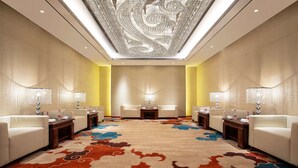 A hotel lobby with a patterned carpet, seating area, and a decorative ceiling. - Ramada Wyndham Zhengzhou Xinzheng (Zhengzhou)