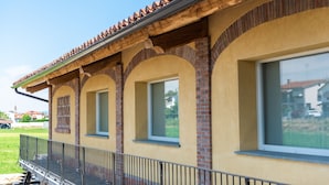 Un edificio con fachada amarilla, arcos de ladrillo y tejado de tejas.