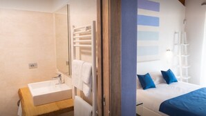 Un dormitorio con cama, mesita de noche y ventana.