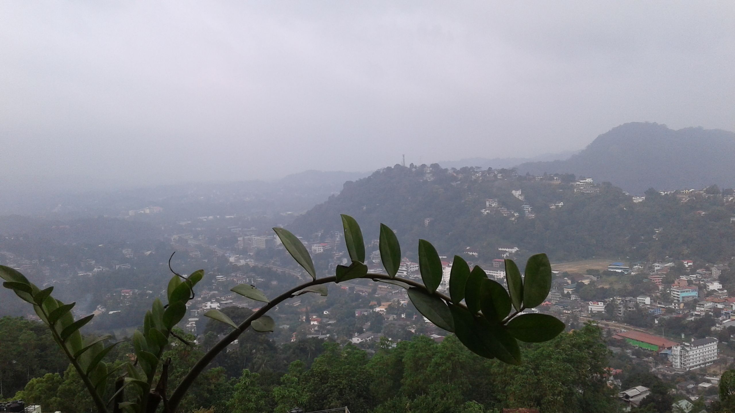 A view of a mountainous landscape with buildings scattered across the hills.