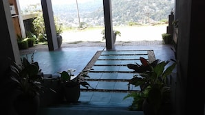A staircase leading to a terrace with a view of a hillside and a body of water. - Lawan One Kandy (Kandy)