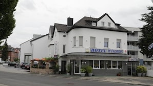 A two-story building with a sign for 'HOTEL MYRONOS' and a restaurant. - Hotel Mykonos (Eschweiler)