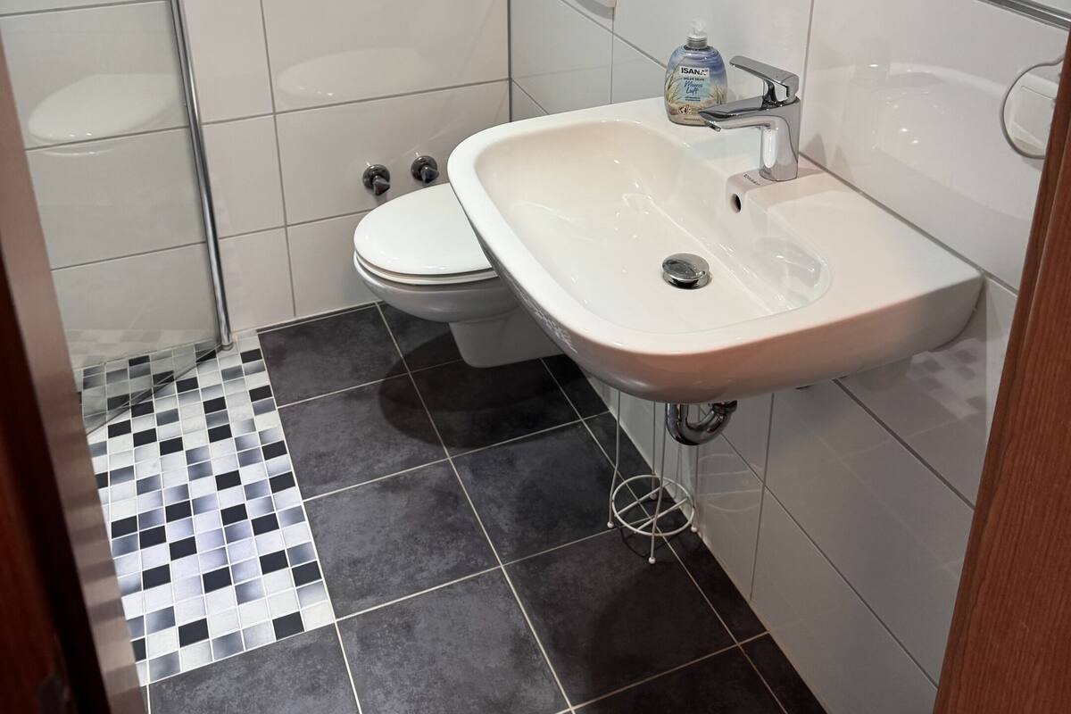 A bathroom with a toilet, sink, and shower.