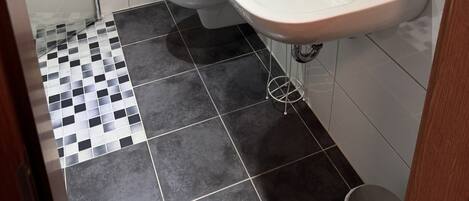 Un baño con inodoro, lavabo y ducha.
